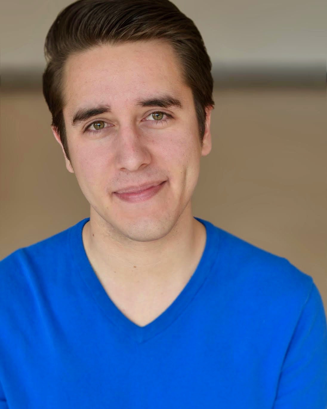 Nolan smiling wearing a blue sweater